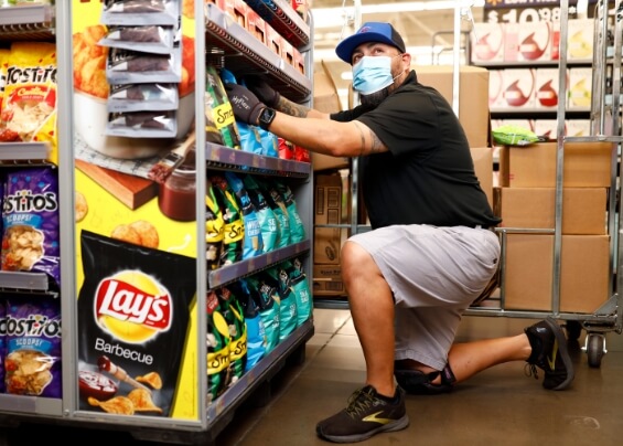 Man with a mask working in a snacks store